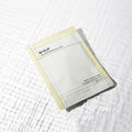 BASUP Aqua Soothing Bio Cell Mask packet with pale yellow edges on a white background with rippling water reflections.