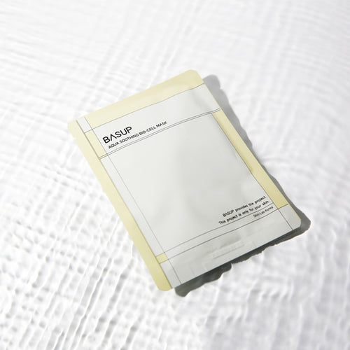 BASUP Aqua Soothing Bio Cell Mask packet with pale yellow edges on a white background with rippling water reflections.